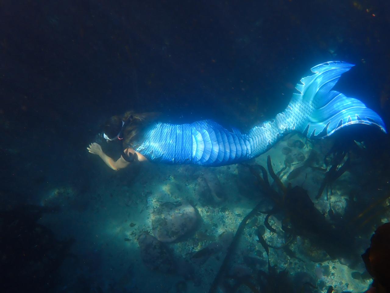 Pink-tailed mermaid beside a swimming pool